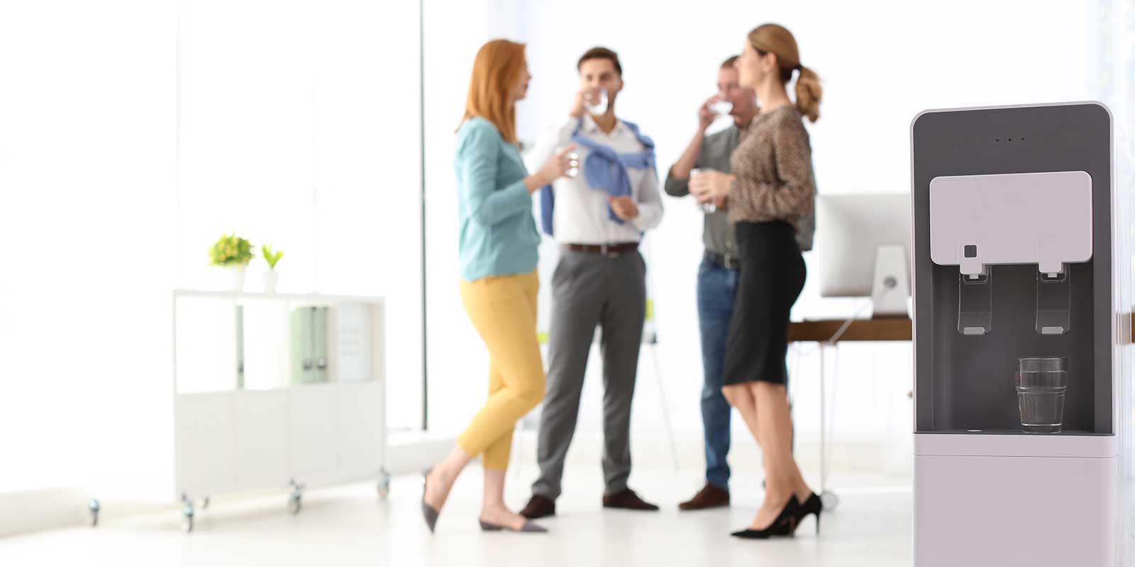 Coworkers enjoying a glass of filtered water from a bottleless free-standing water cooler