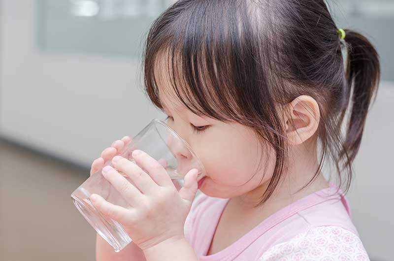 Hawaiian girl drinking a glass of purified water