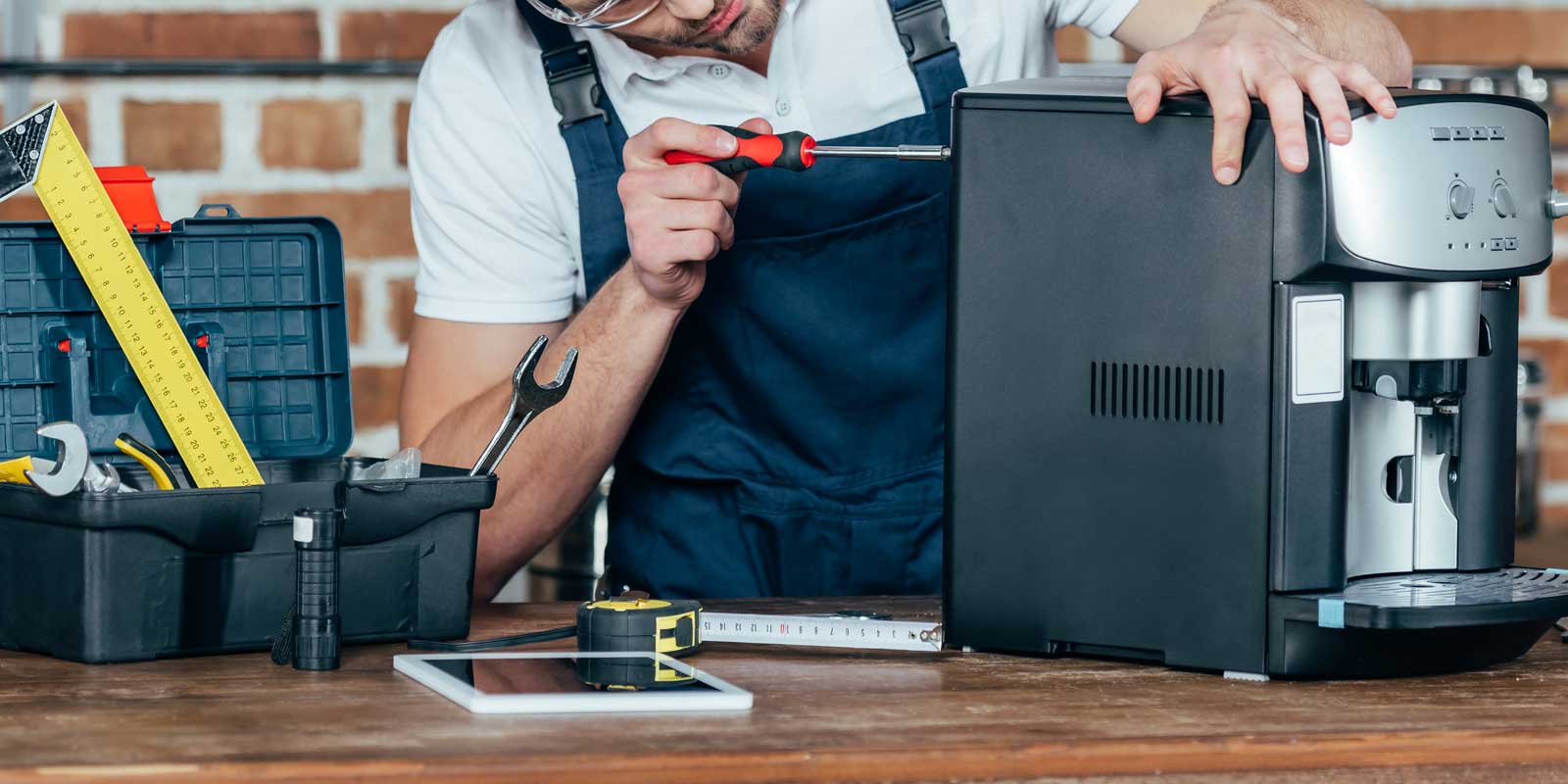 Man performing maintenance & repairs on a coffee machine