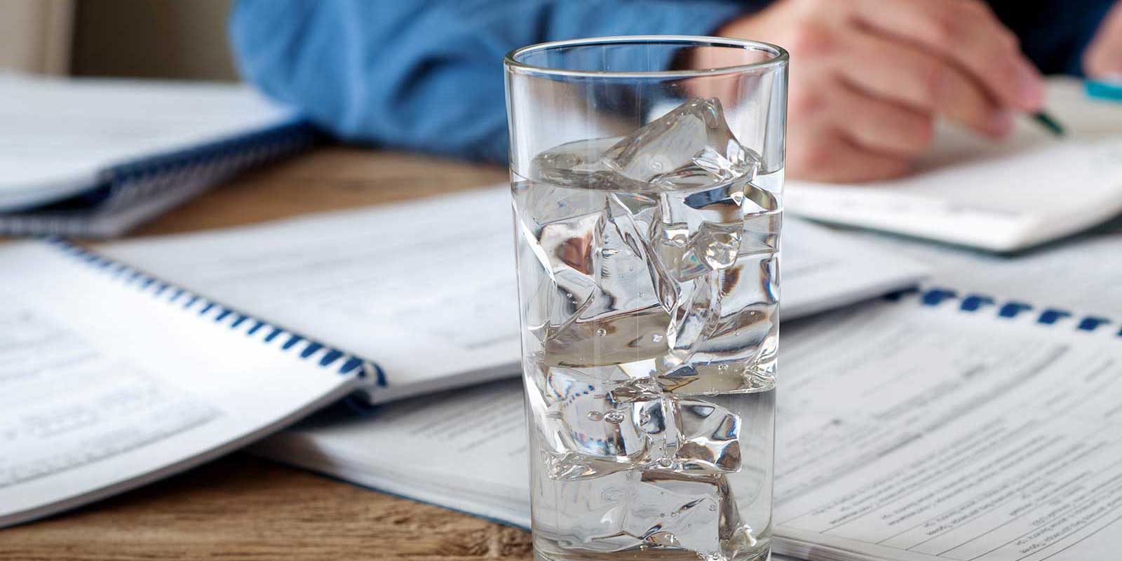 Man with a glass of ice water he dispensed from a bottleless water cooler