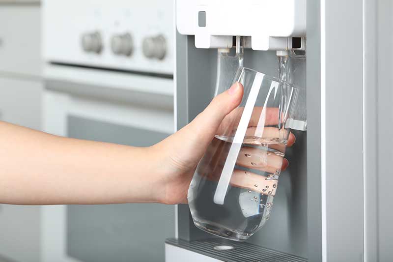 Office employee using a bottleless water cooler
