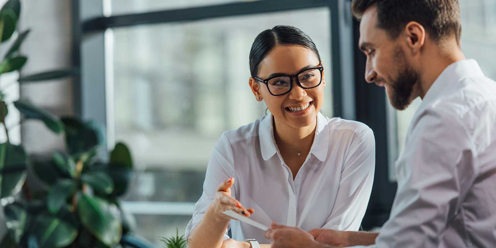 Woman handing her coworker a note about bottleless water coolers