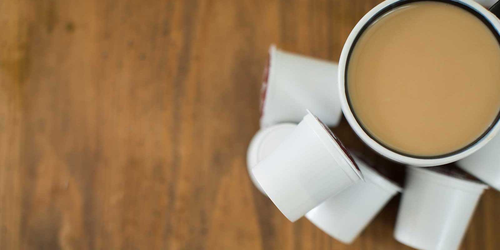 Stack of Keurig pods next to coffee cup