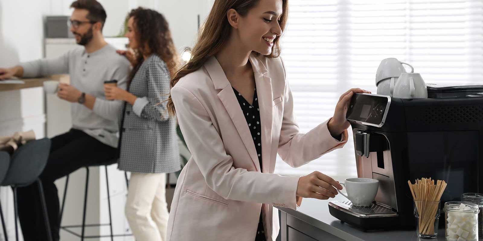Woman using an office coffee machine in the morning