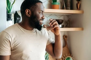 black man drinking water from glass