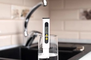 man testing water ph from faucet