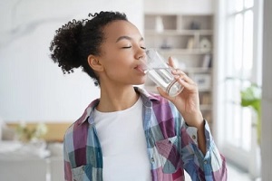 teen girl drinking water from glass