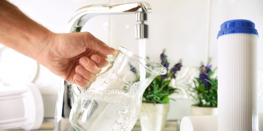 hand filling jug from a tap with filtered osmosis water