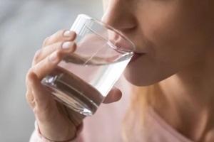 close up image woman holds glass drinking still water